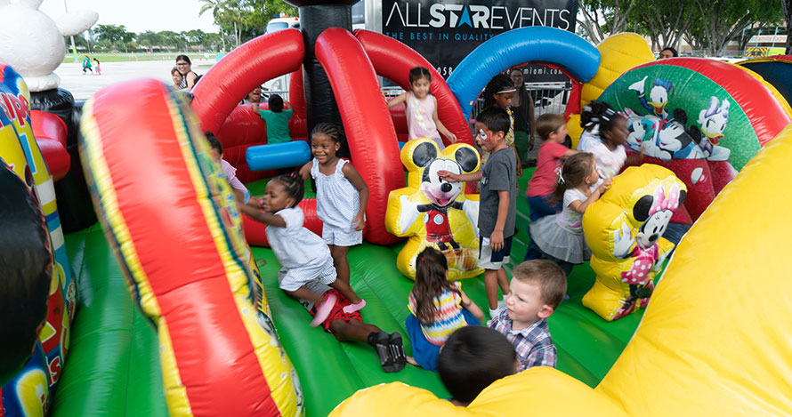Los niños se divierten en una casa de brinco en The Children's Trust Family Expo.