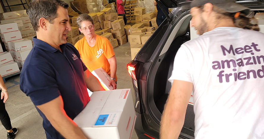 The Children's Trust's President and CEO James Haj loads books during a distribution event in the summer. 