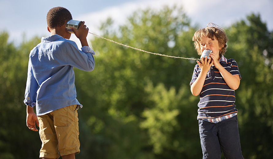Boys communicating using two cans tied with string.