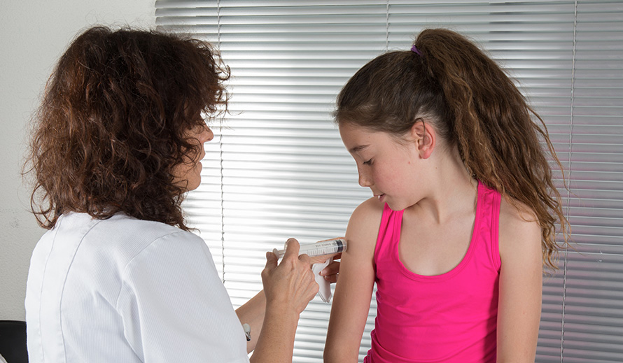 Girl in a clinical setting getting a vaccine.