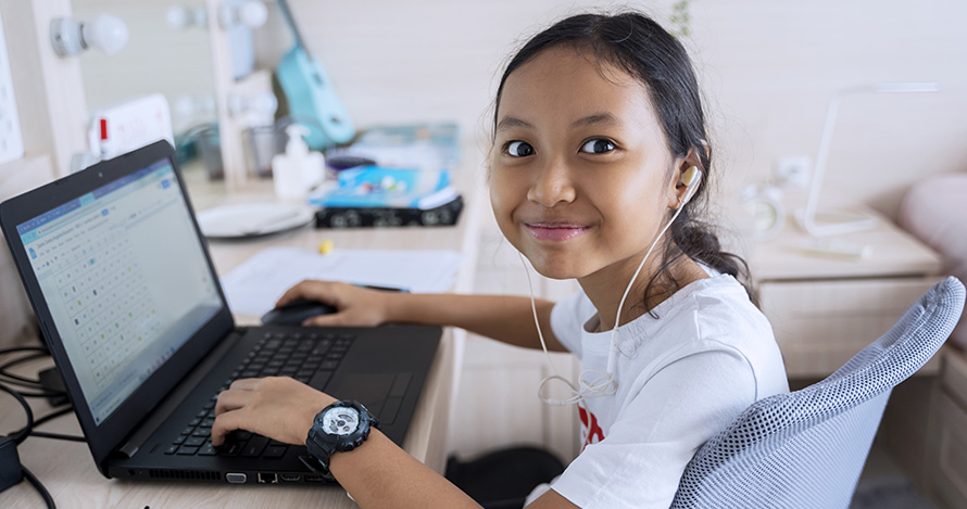 A young girl enjoys online learning from home. 