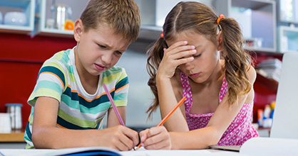 Frustrated young brother and sister doing homework