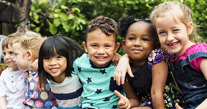Smiling group of multiracial children, hugging.