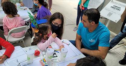 The Children's Trust President and CEO James R. Haj sitting with children at the 2021 Miami International Book Fair. 