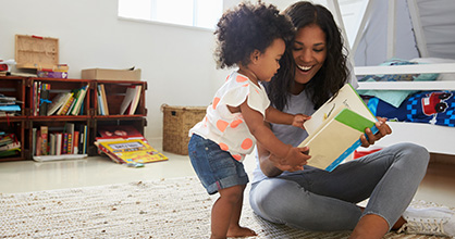 A woman reads to her young daughter.