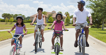 An African American family takes a summer bike ride. 
